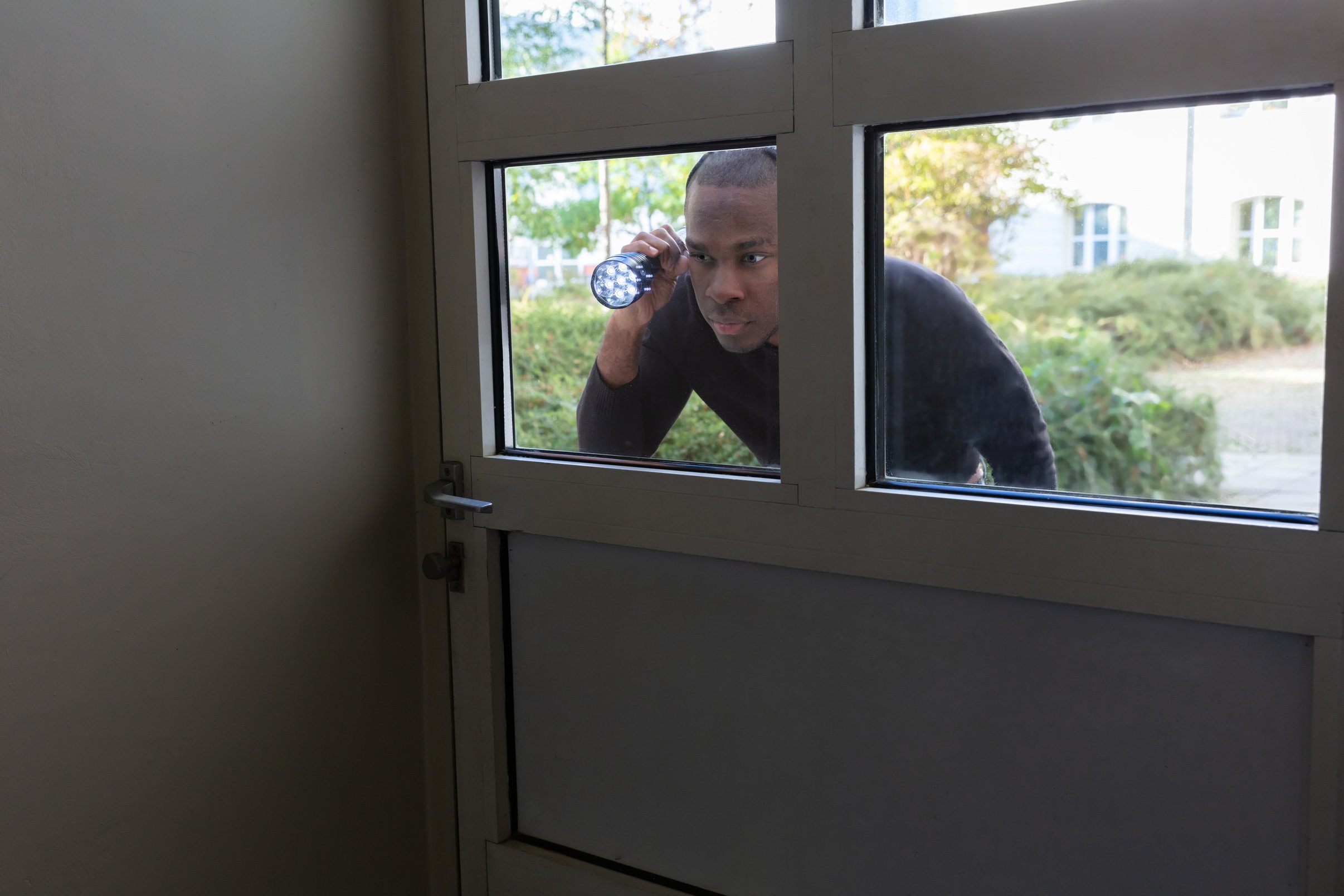 Man Peeking Through Glass Door